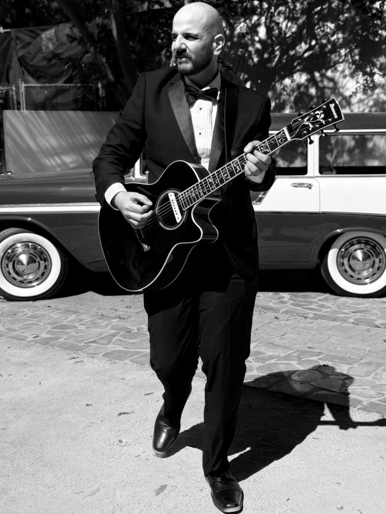 J. Daniel performing wedding guitar in formal attire